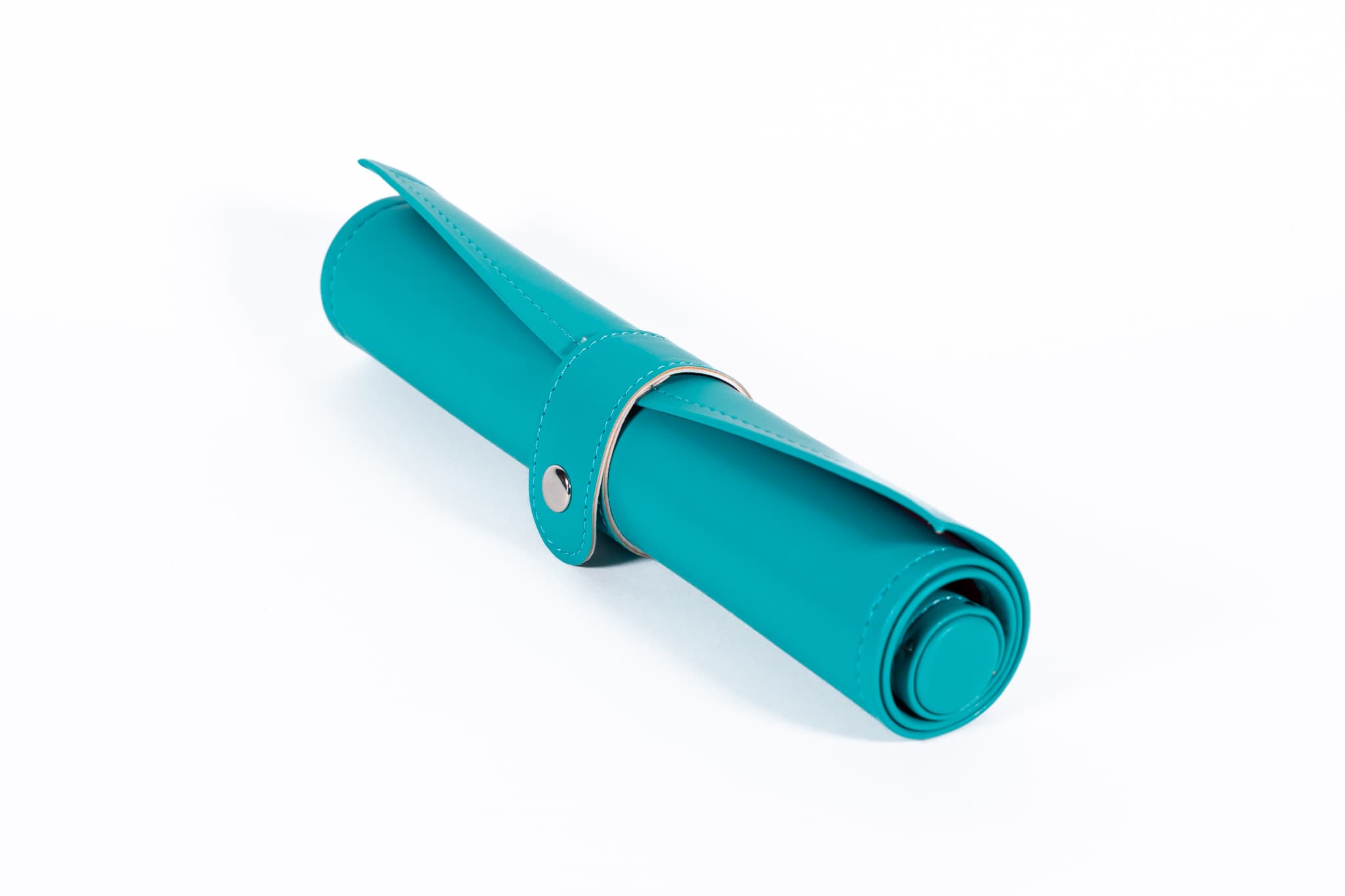 Rolled turquoise leather backgammon board on a clean studio background